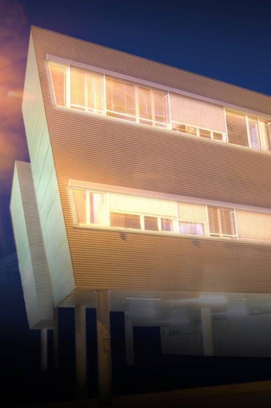 Moderne Architektur auf Stelzen in Graz mit beleuchteten Fenstern in der Dämmerung