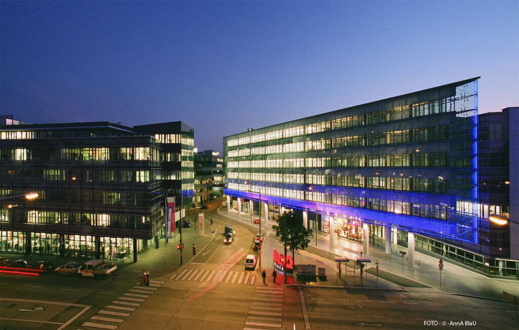 Modern buildings of the Euro Plaza in Vienna illuminated at dusk with street traffic