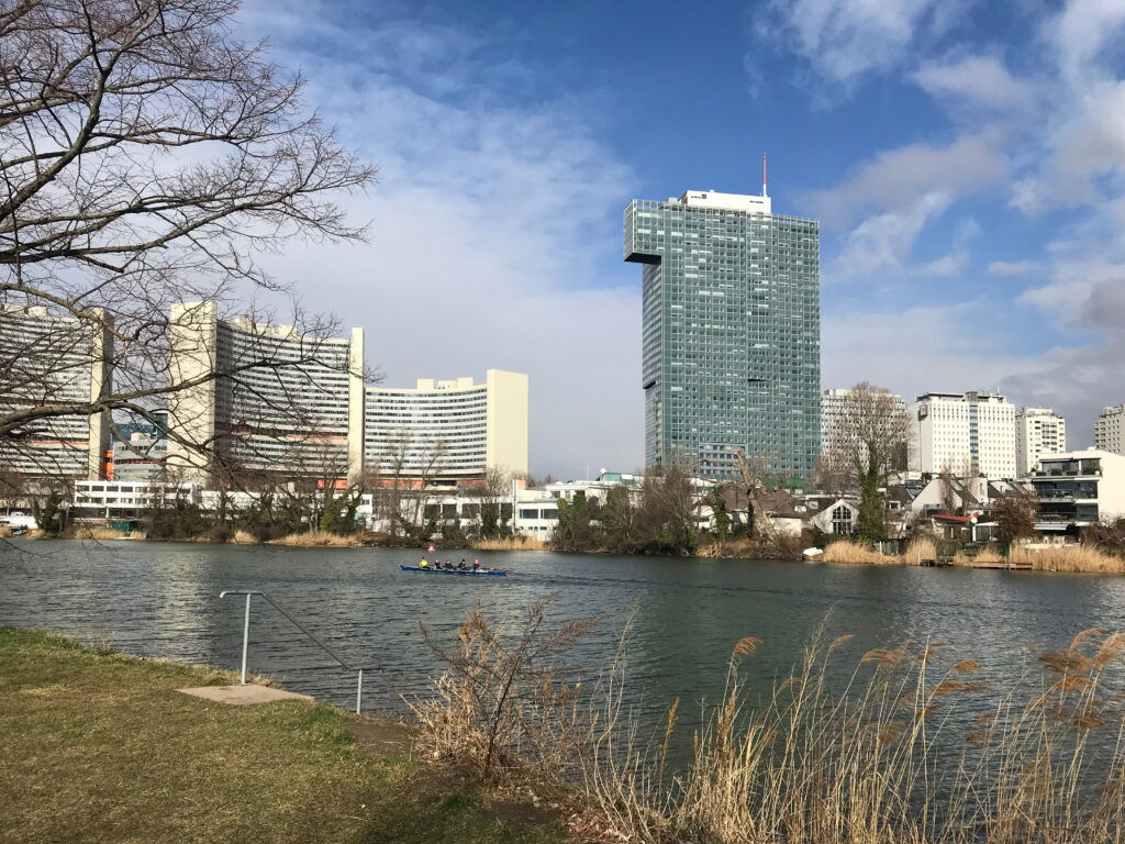 Ruderboot auf der Alten Donau mit dem IZD Tower und der Wiener Skyline im Hintergrund