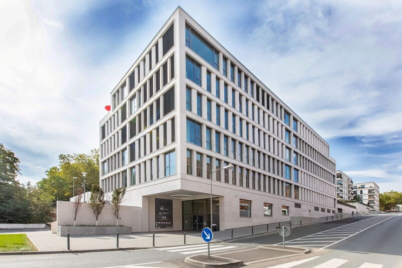 Außenansicht des modernen Ecos Office Center Gebäudes mit großen Fenstern und weißer Fassade vor blauem Himmel