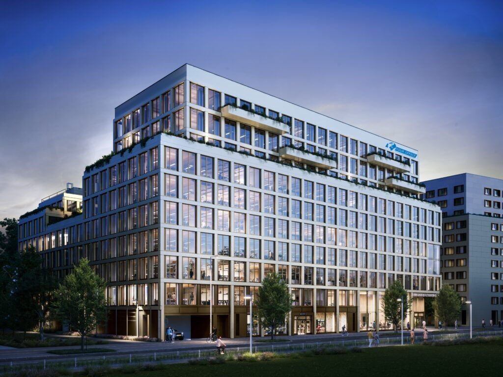 Moderne Architektur des Leopoldsquartier Bürogebäudes mit großen Glasfronten und begrünten Terrassen bei Tag.